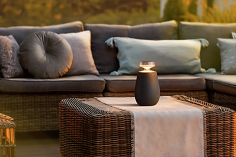 LG XBOOM 360 XO2T 置於戶外桌上。